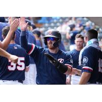 Brian O'Keefe receives high fives in the Tacoma Rainers dugout