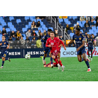 Louis Perez of North Carolina FC (center) eyes a loose ball